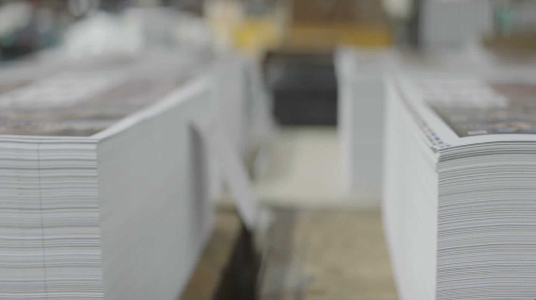 Stacks of printed sheets moving through a commercial printing press