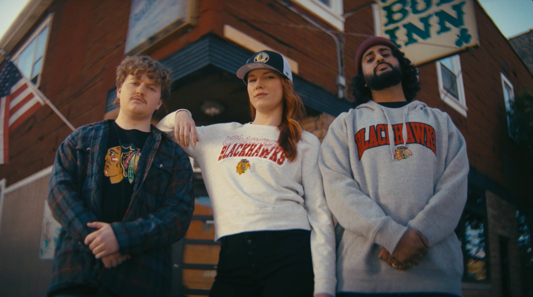 Three Chicago sports fans standing outside a neighborhood bar