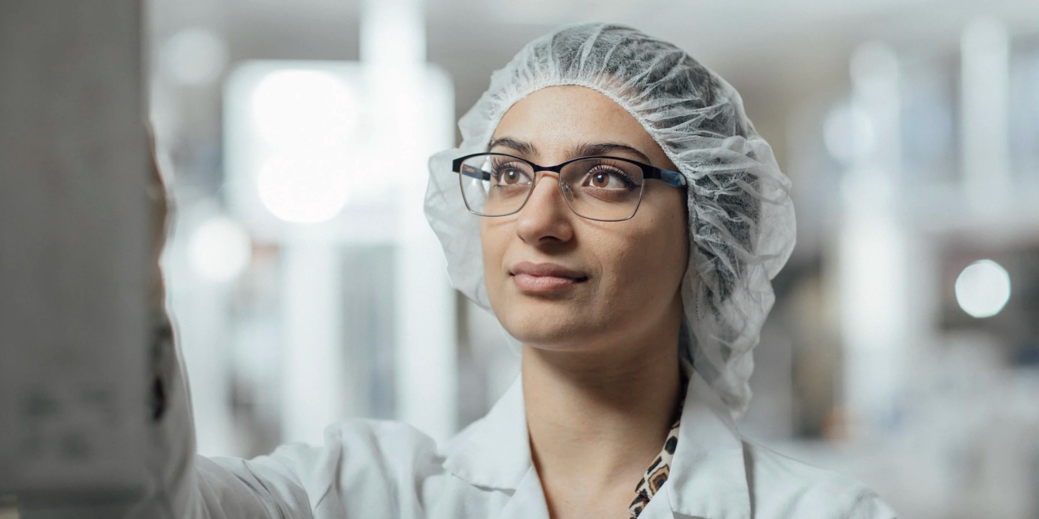 Scientist in safety glasses inspecting laboratory equipment