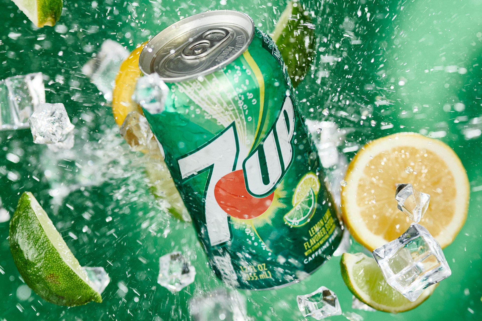 7UP can surrounded by citrus, ice, and splashing water