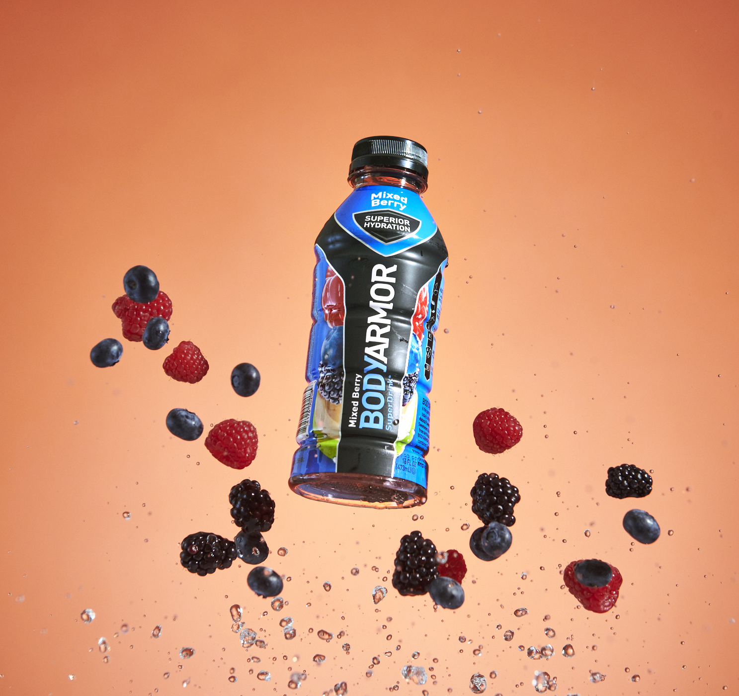 BODYARMOR sports drink surrounded by berries in a studio composition