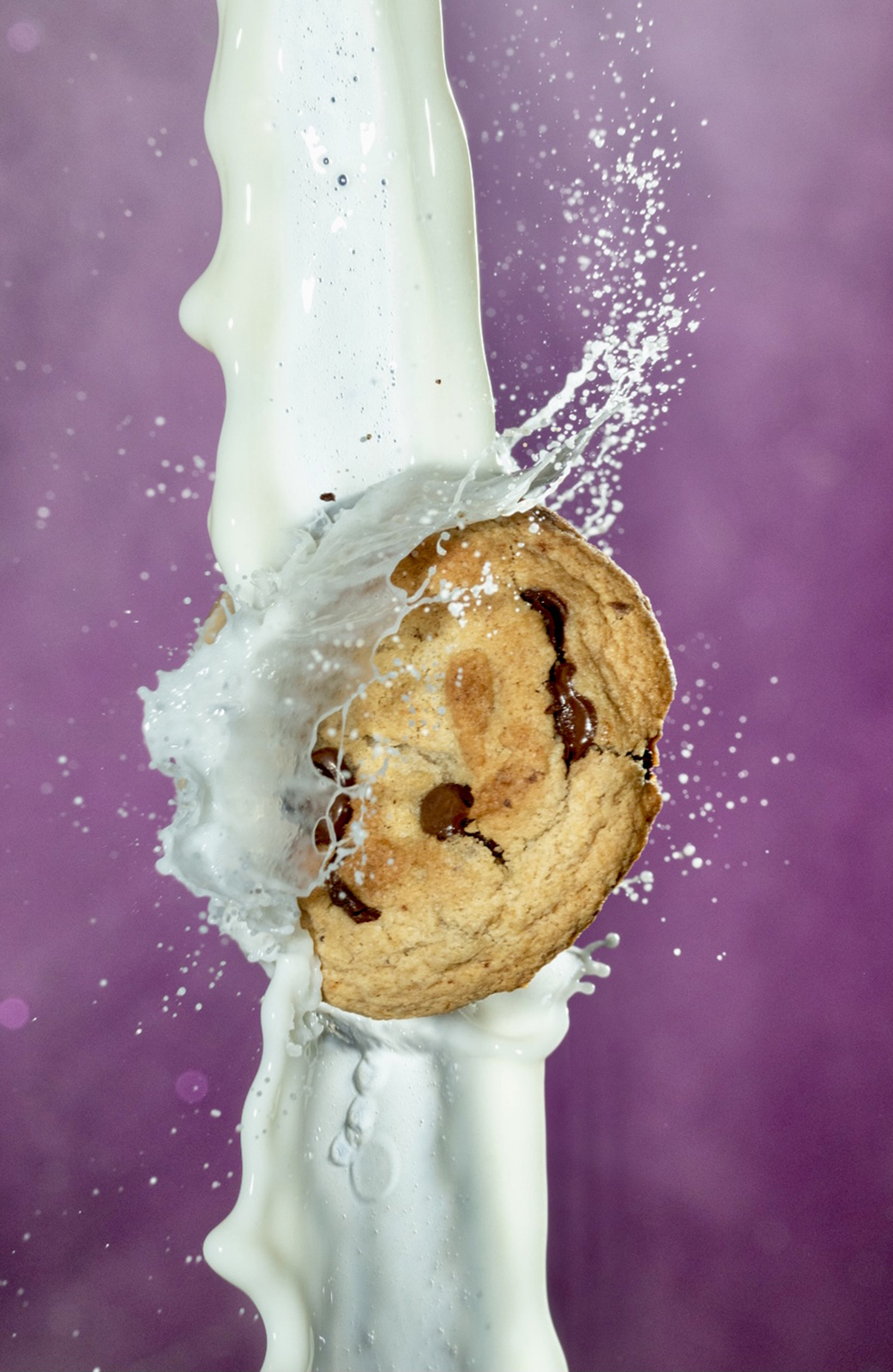 Chocolate chip cookie colliding with a stream of milk